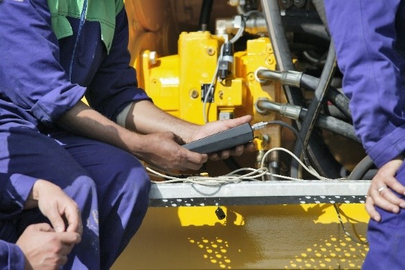 People in overalls and yellow machinery