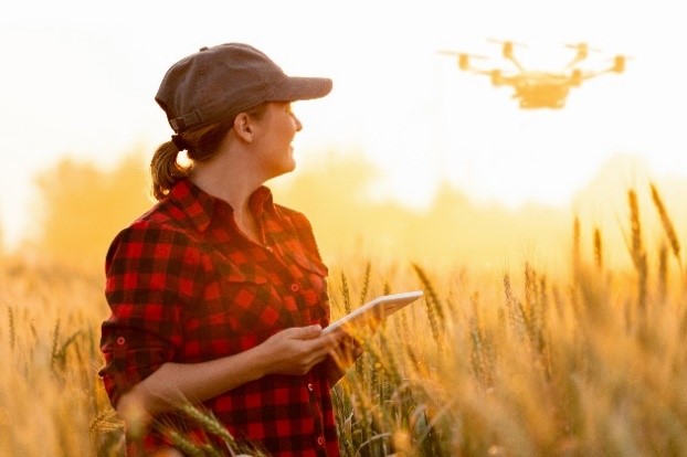 Women in cap standing in crop under sunlight
