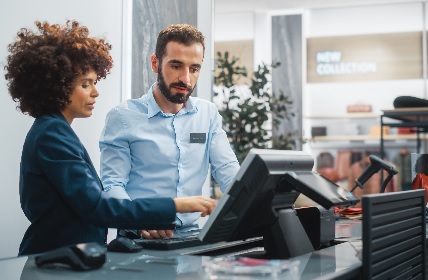 Image of two people standing behind a cash register
