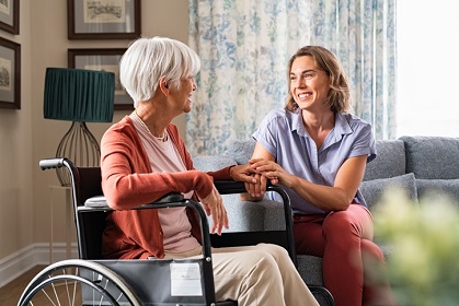 Carer talking to an elderly woman in a wheel chair in her home