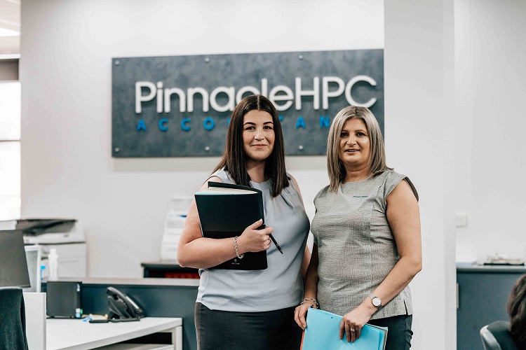 2 Pinnacle HPC staff standing at desks