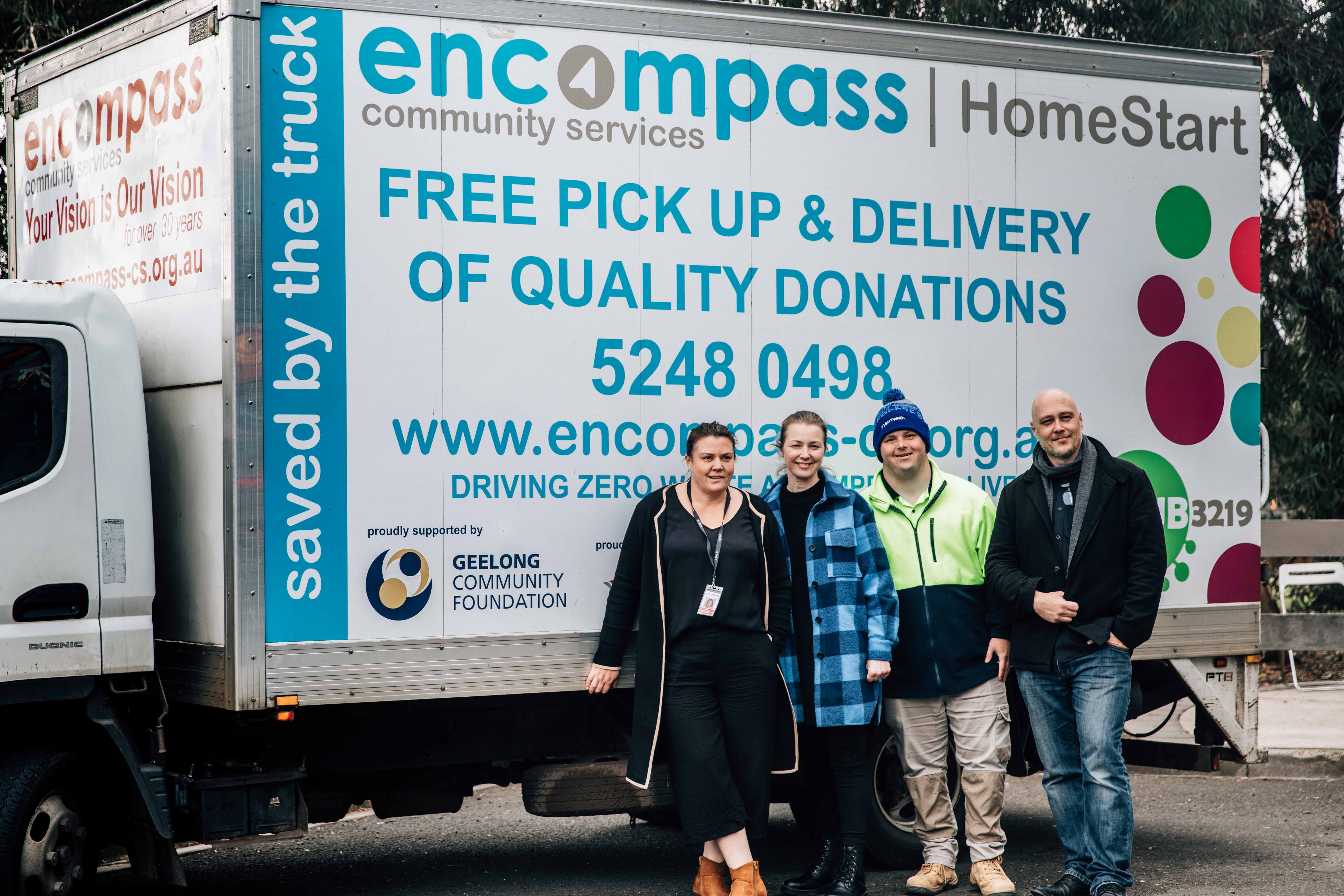 Image of four people standing in front of a truck