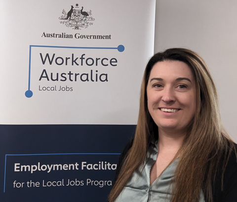 The Employment Facilitator for Inner Metropolitan Melbourne, standing in front of a Workforce Australia banner.