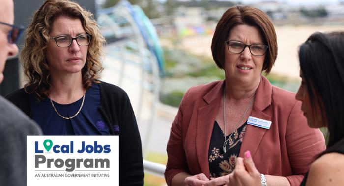 Local Jobs and Skills Taskforce members having a discussion on a balcony overlooking a beach