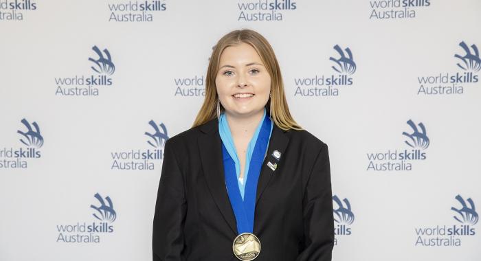 Graphic designer Indy Griffiths is pictured smiling as she wins an award.