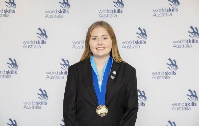 Graphic designer Indy Griffiths is pictured smiling as she wins an award.