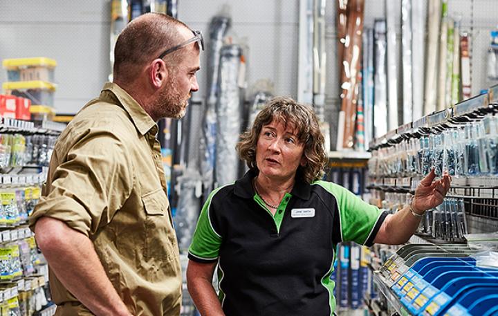 Mature age woman standing with a customer in a hardware store 