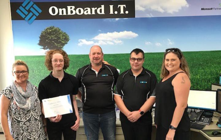 People standing in front of a sign reading OnBoard I.T.