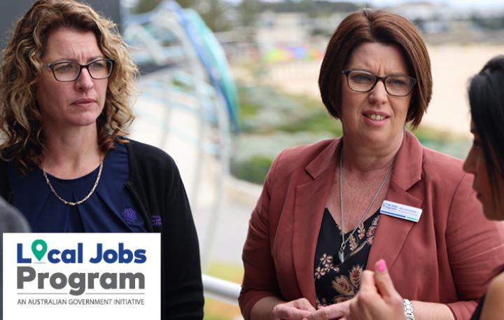 Local Jobs and Skills Taskforce members having a discussion on a balcony overlooking a beach