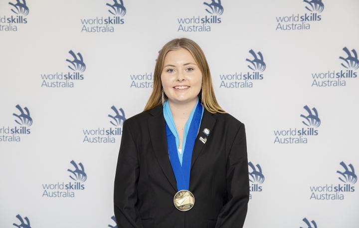 Graphic designer Indy Griffiths is pictured smiling as she wins an award.