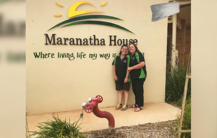 NWEP Participant Melissa (left) and CEO of Maranatha House Debra stand in front of the Maranatha House logo, which states “Where living life my way is made easy”