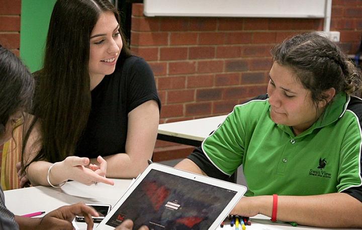 Follow the Dream tutor Tenae Rivers is pictured helping two students study to prepare for an exam. 